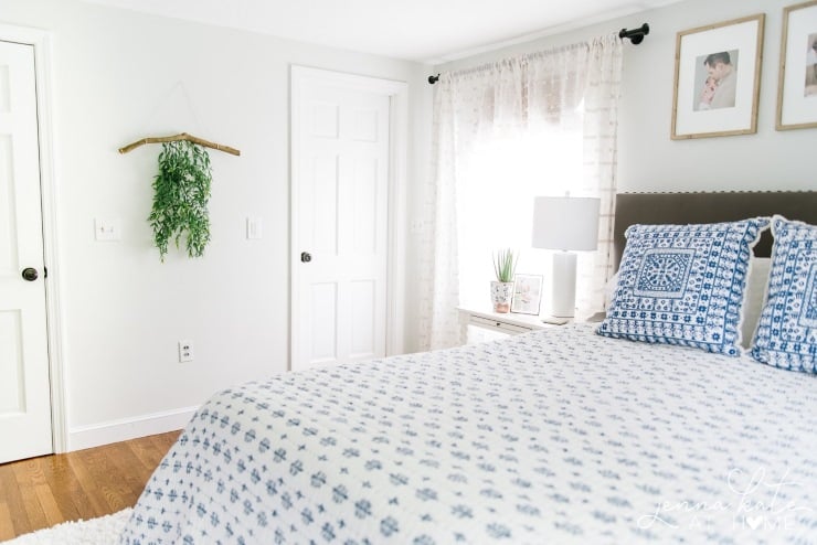 Minimal branch wall hanging with cascading greenery displayed in a bright bedroom