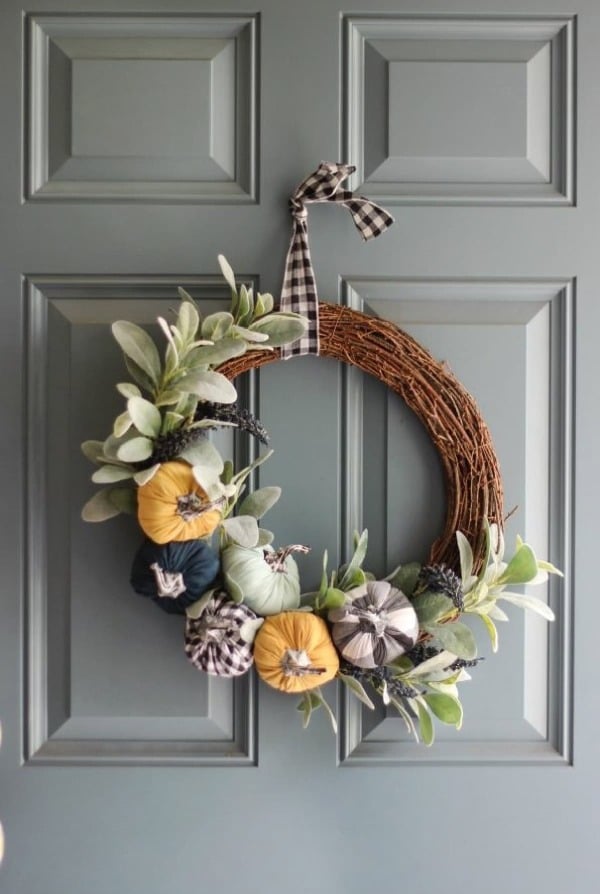 Grapevine wreath with muted fabric pumpkins, greenery, and gingham ribbon