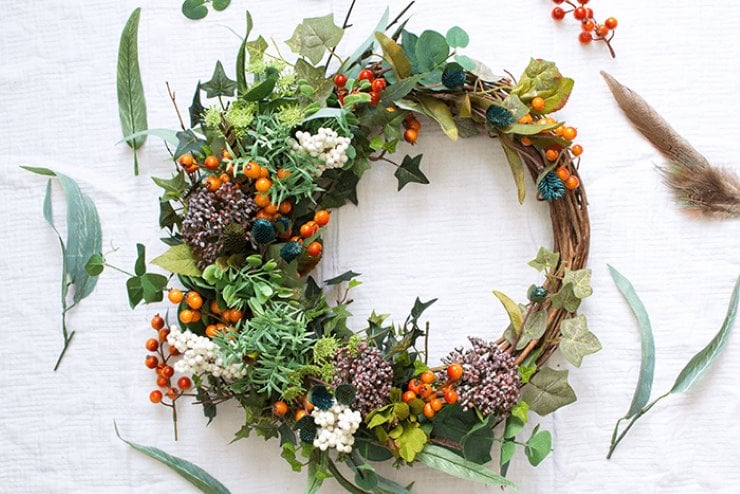 Faux foraged fall wreath filled with greenery, berries, and natural accents