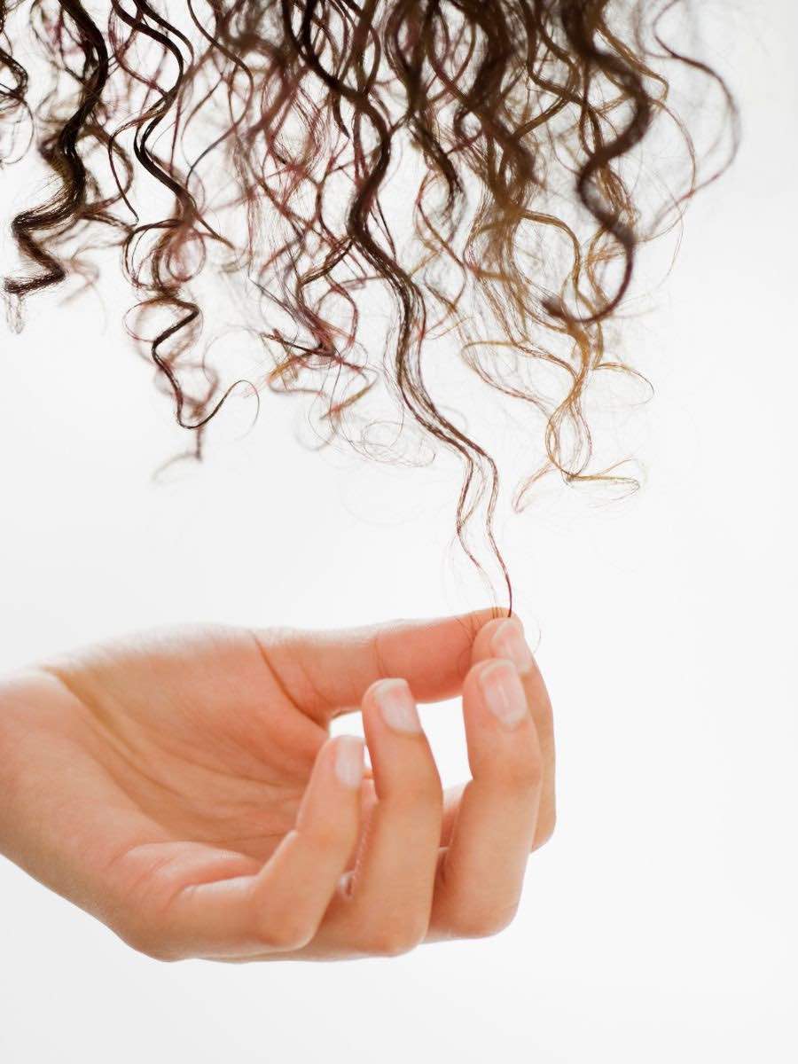 hand touching the ends of curly hair