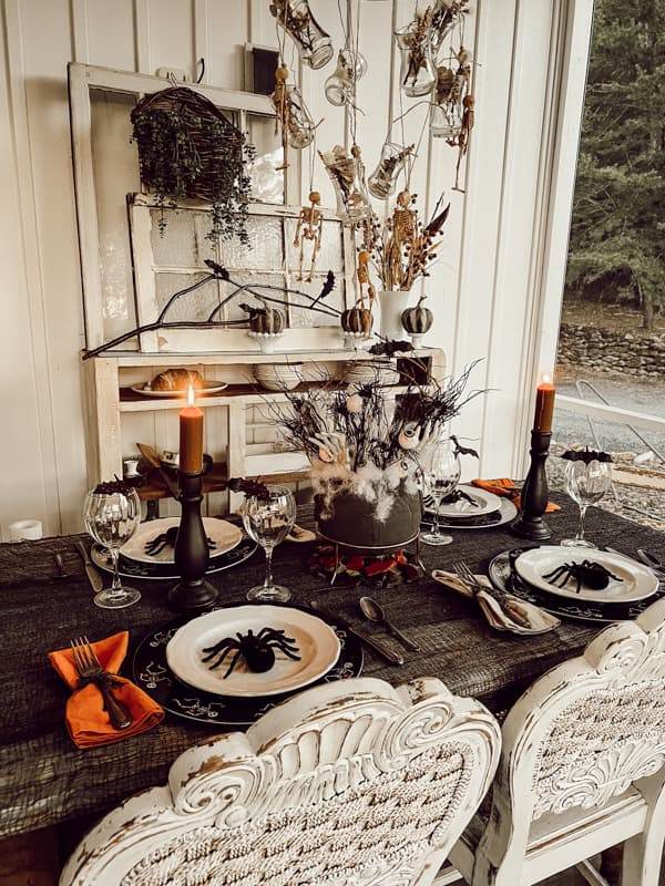 Halloween dining table with black candles, spider plates, and spooky centerpiece decor