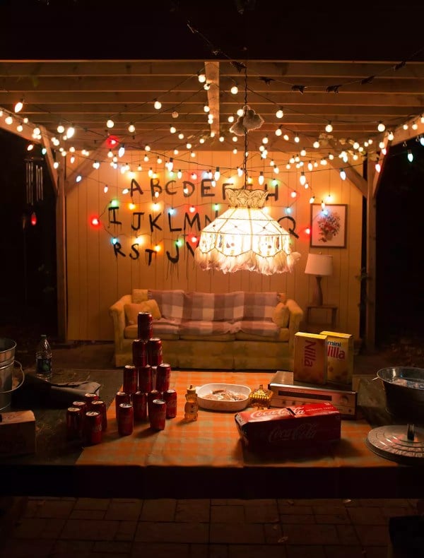 Stranger Things inspired setup with string lights, alphabet wall, and retro furniture