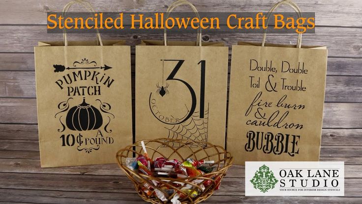 A brown paper gift bag decorated with Halloween themed stencil paintings on the front