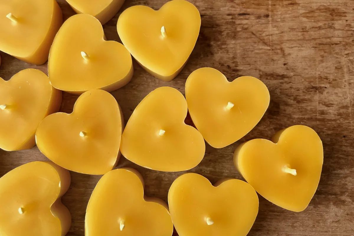 Several heart shaped tea candles photographed from above on a wooden background
