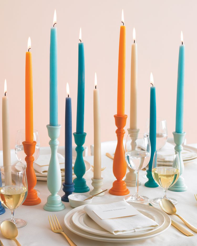 colorful candles with matching candle holders decorating a table
