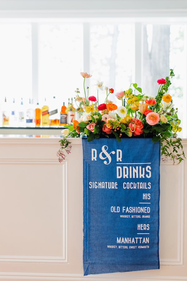 blue banner draped over bar displaying signature cocktails
