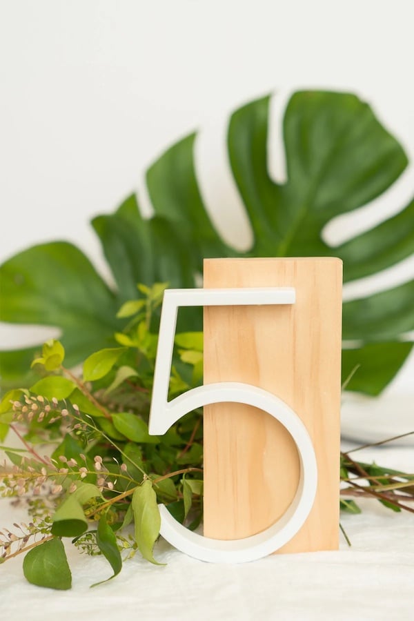 simple wedding table number idea- a white number cutout glued to a clean cut piece of wood for a modern look