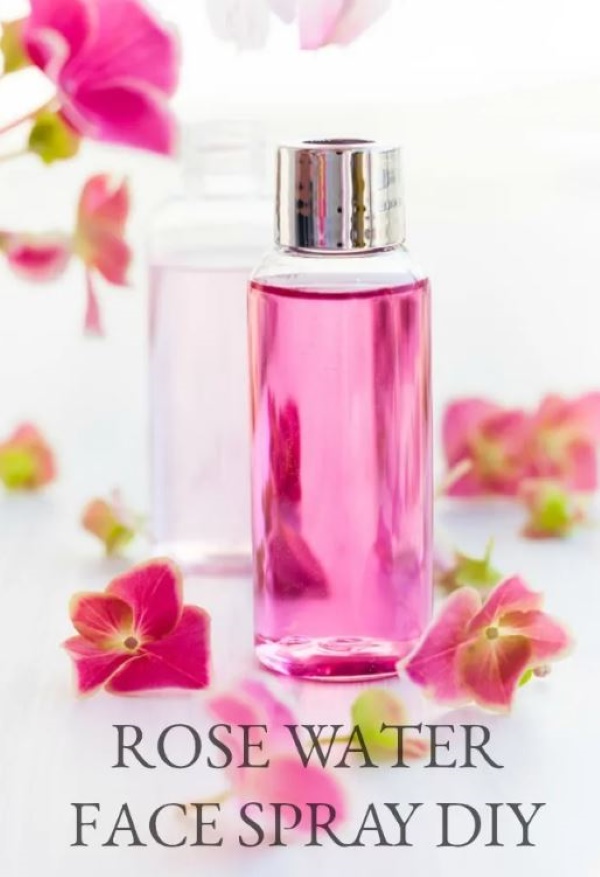 DIY rose water face spray in a glass bottle with pink flowers