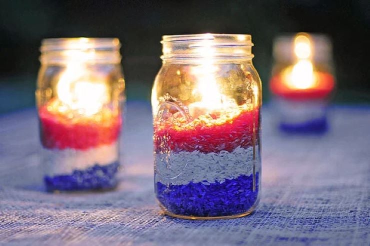 Mason jar candles filled with red, white and blue rice as the layers
