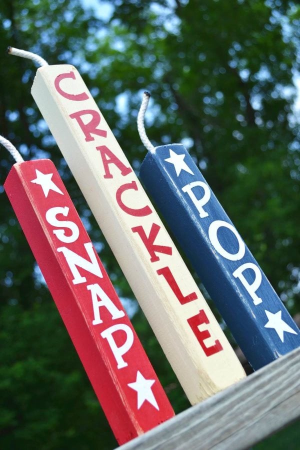 Tall and skinny red, white and blue wooden firework signs that read 'snap, crackle, and pop'