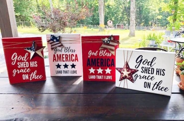 Festive red, white and blue painted wooden signs that read 'God shed his grace on thee,' and 'God bless America - land that I love,'