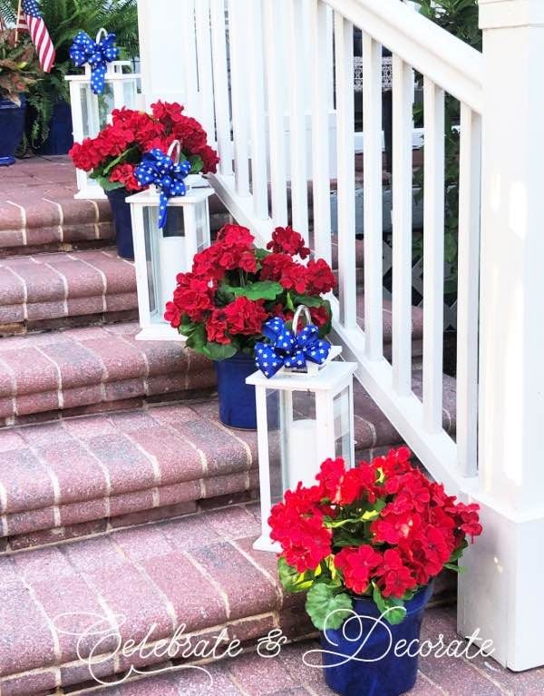 Front porch steps with alternating white lanterns and red and blue flower pots