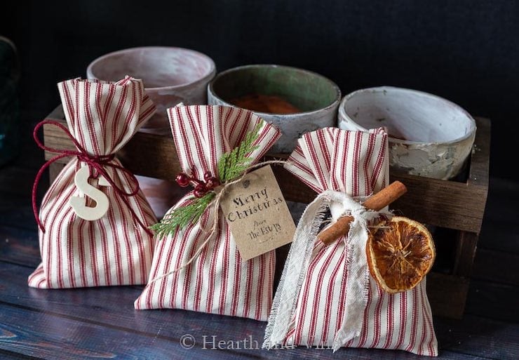striped diy party favor bags tied with string and small decorations like herbs, cinnamon, or gift tags