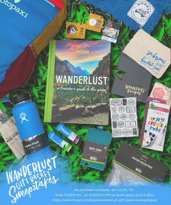 Assortment of travel themed gifts including a travel book, water bottle, journal, snacks, and outdoor adventure gear