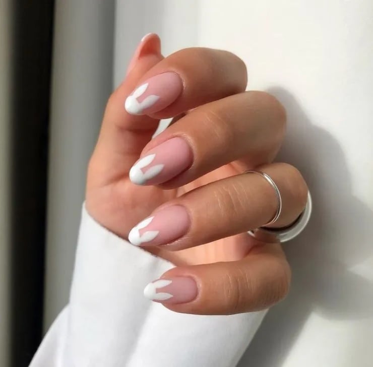 French nails with white bunny ears on a soft pink base, cute and minimalist Easter bunny nail design.