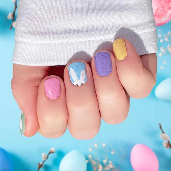 Pastel Easter nails accented with a bunny sticker and flecked nail polish inspired by colorful Easter eggs.