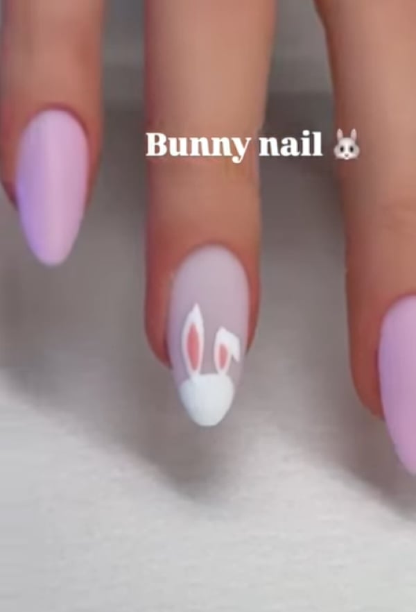 Soft purple Easter nails with a bunny ear design on the nail with a pastel accent.